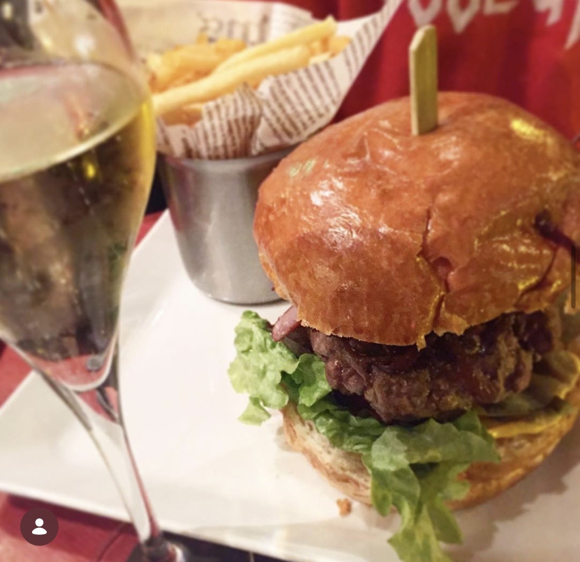 Un burger avec des frites et une coupe de champagne